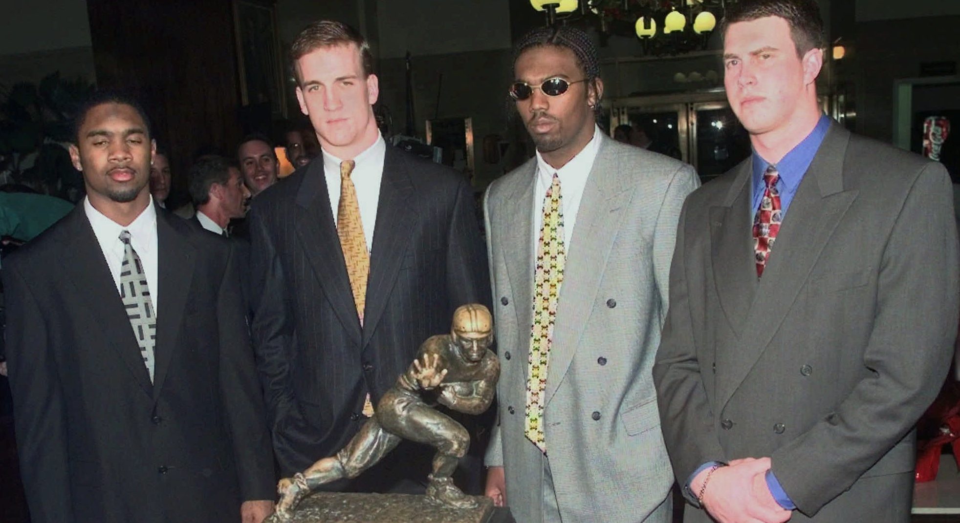 Heisman Trophy candidates, from left to right, Michigan's Charles Woodson, Tennessee's Peyton Manning, Marshall's Randy Moss and Washington States's Ryan Leaf pose in the lobby of the Downtown Athletic Club with the Heisman trophy prior to the start of the ceremony Saturday, Dec. 13, 1997, in New York. (AP Photo/Adam Nadel)